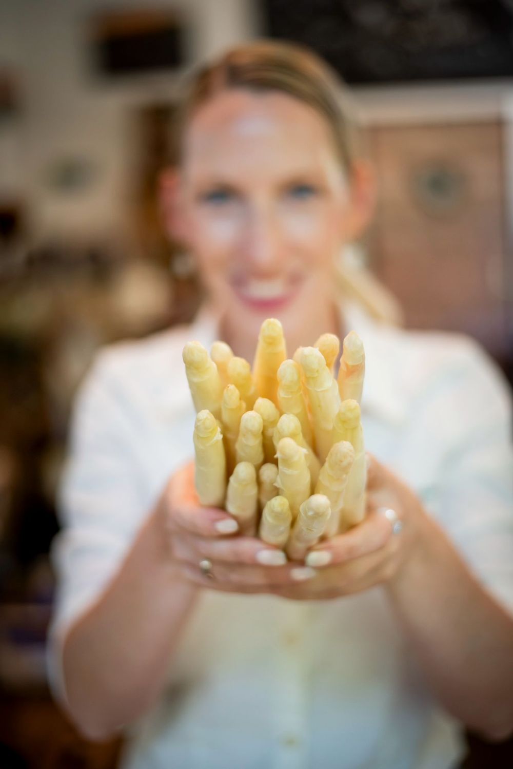 Frau hält Spargel in die Kamera