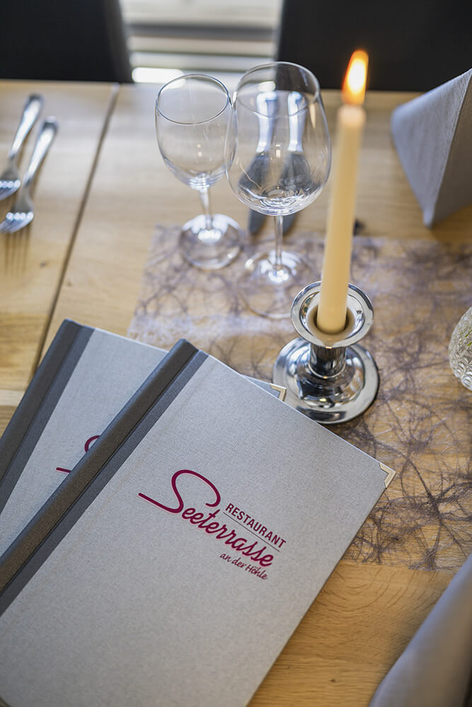 Die Karte des Restaurant Seeterrasse nebst einer Tischdeko mit Kerze